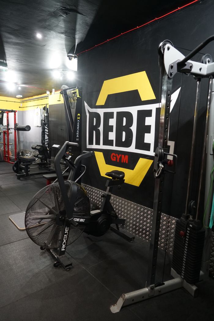 Rebel Gym branded wall with cardio equipment